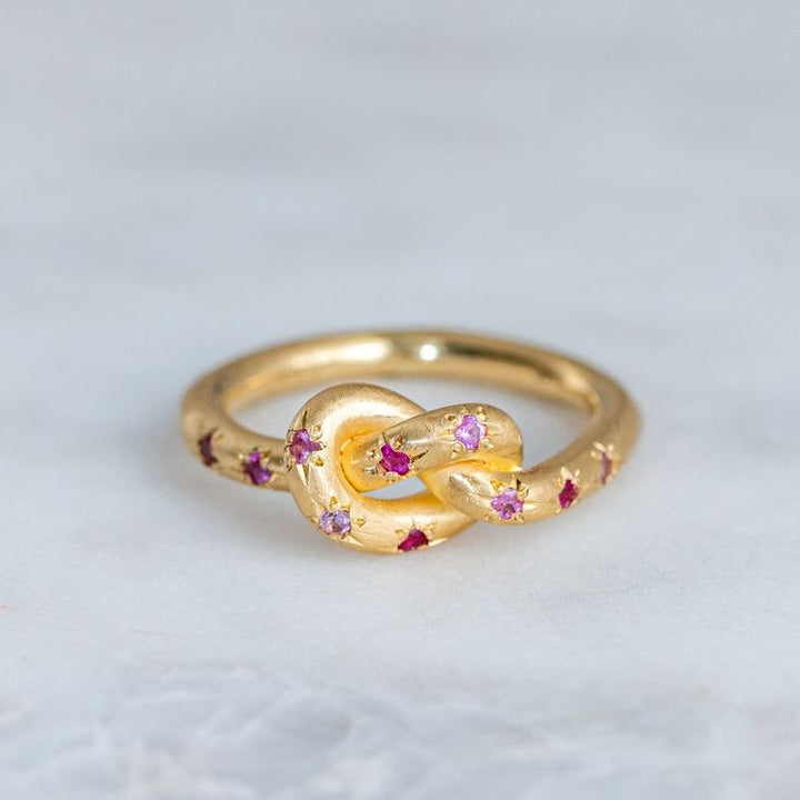 Anillo retro rosa con nudo dorado